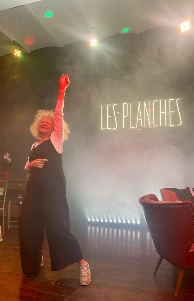 Une invitée danse sur scène dans la fumée et les projecteurs